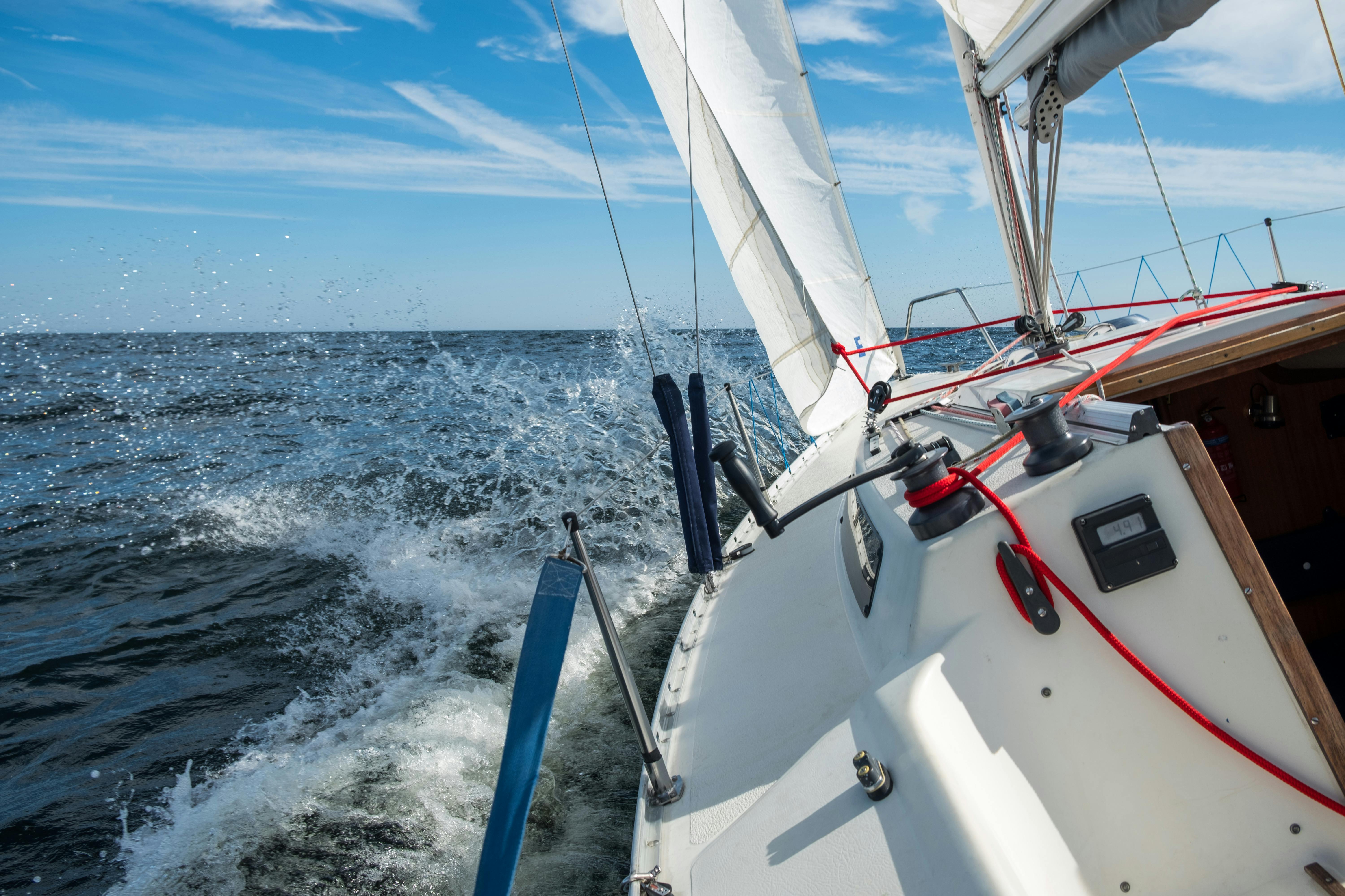 A white sailboat on the blue ocean.